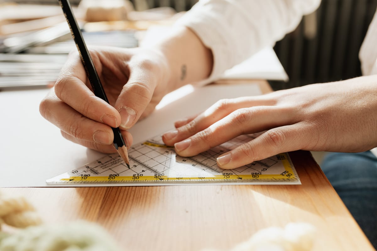 Tangan anak menggambar dengan pensil dan penggaris segitiga